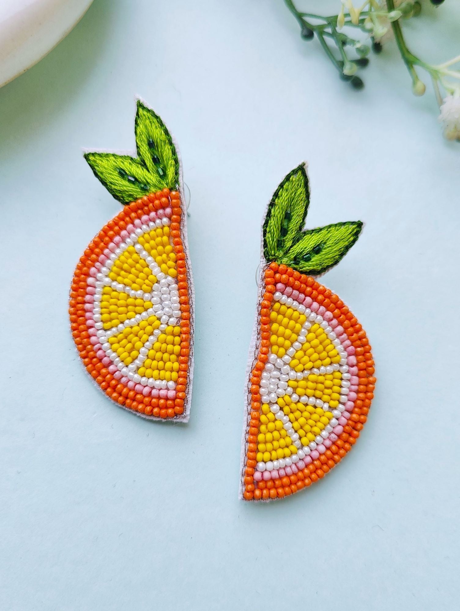 Handcrafted, ethnic orange beaded stud earrings designed for festive occasions and weddings. These lightweight, vibrant orange slice earrings are crafted for mesmerizing elegance.