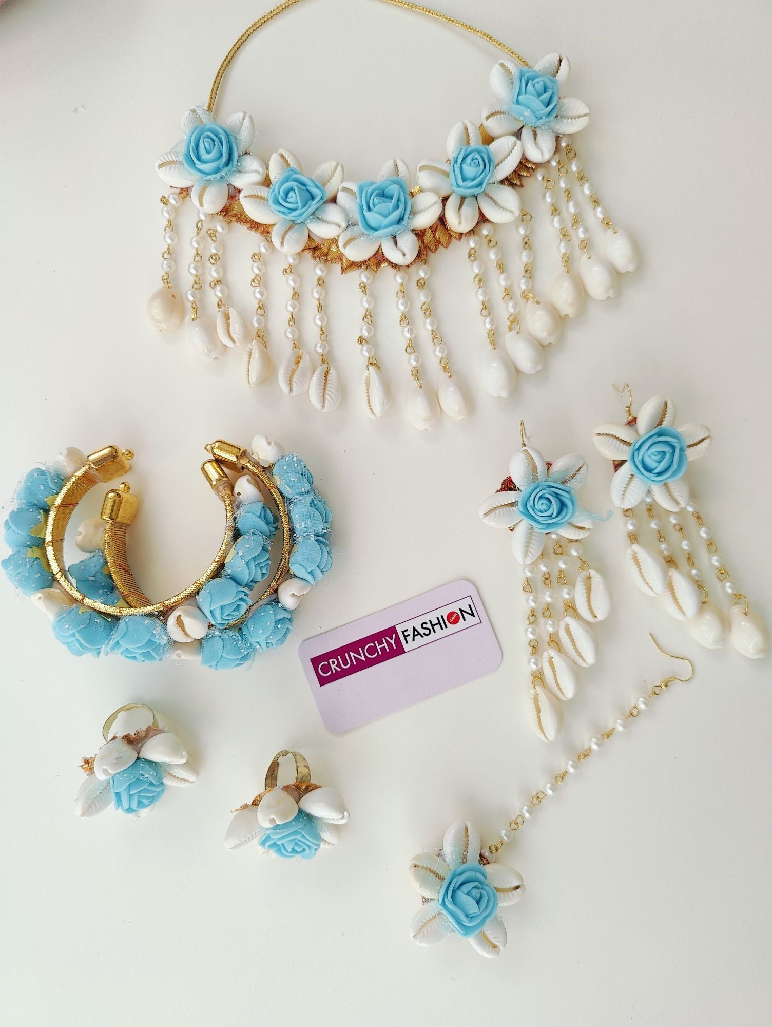 Aqua blue flower-themed, handmade cowrie shell bridal jewellery set, ideal for haldi and wedding occasions