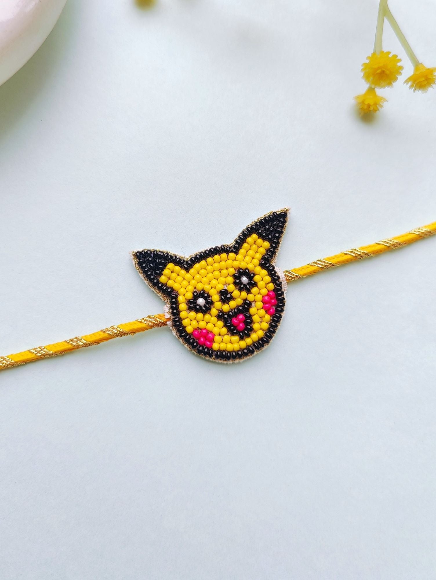 Multicolor Handmade Pikachu Rakhi for kids, easily adjustable, with Roli and Chawal for Raksha Bandhan.