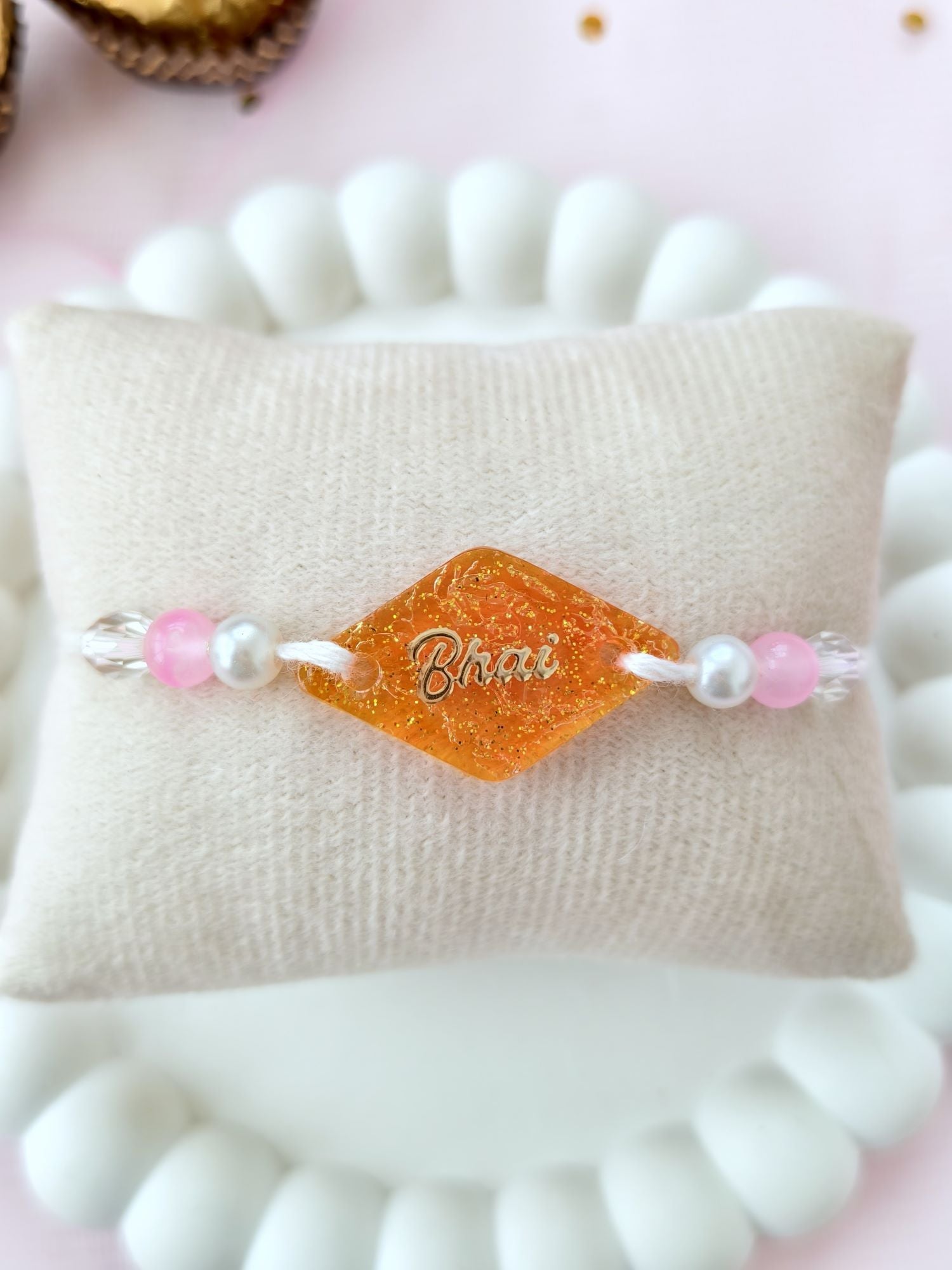 handmade orange resin rakhi 2026, sparkle bhai rakhi design