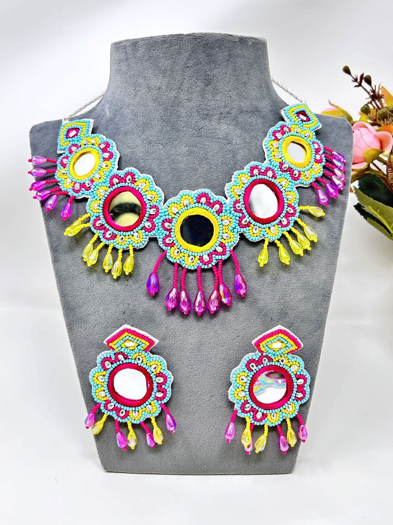 Image of a multicolored, handcrafted bridal jewellery set for women with floral designs. The beaded and pearl set is ideal for wedding, haldi, and mehndi occasions.