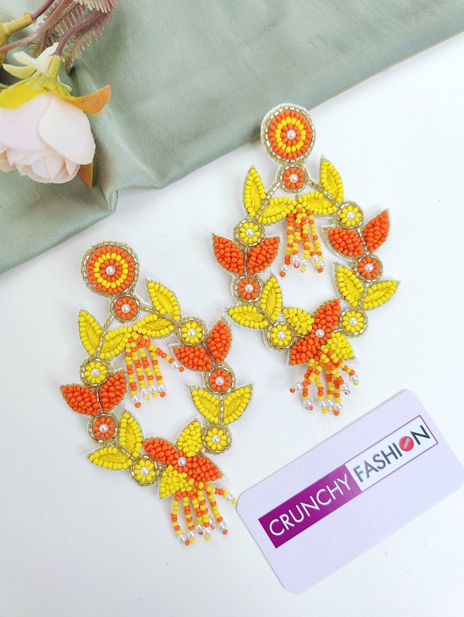 Handmade yellow-orange beaded and pearl bridal jewellery set with floral theme for haldi-mehndi celebration