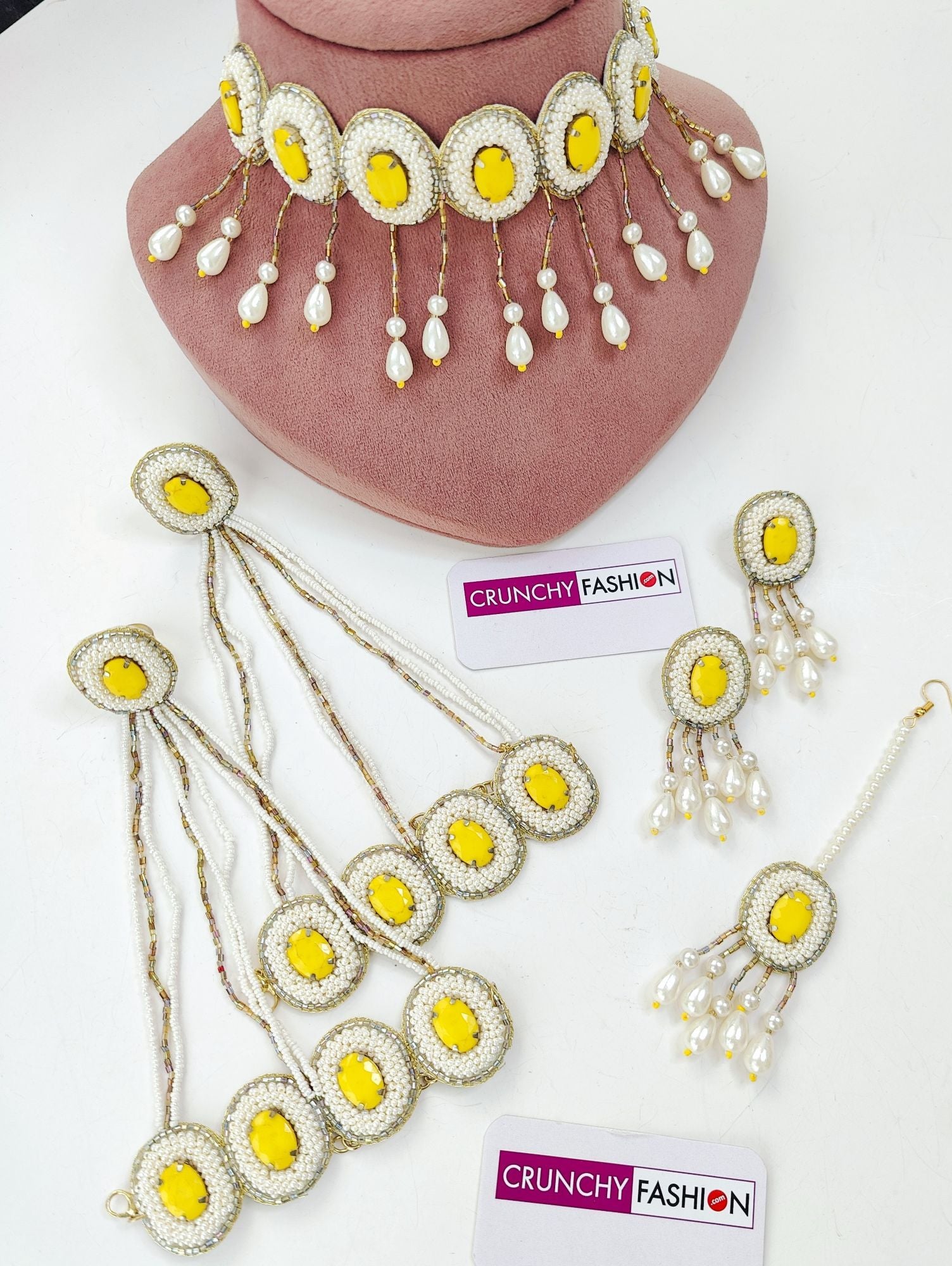 Yellow pearl jewelry set: floral necklace, earrings, maang tika, hathphools for haldi-mehndi from Designer Carnival.