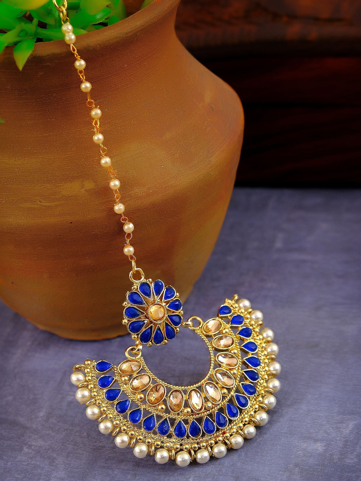New design gold maang tikka with asymmetrical ethnic motif in a blend of blue and alloy for an exuberant festive look for women
