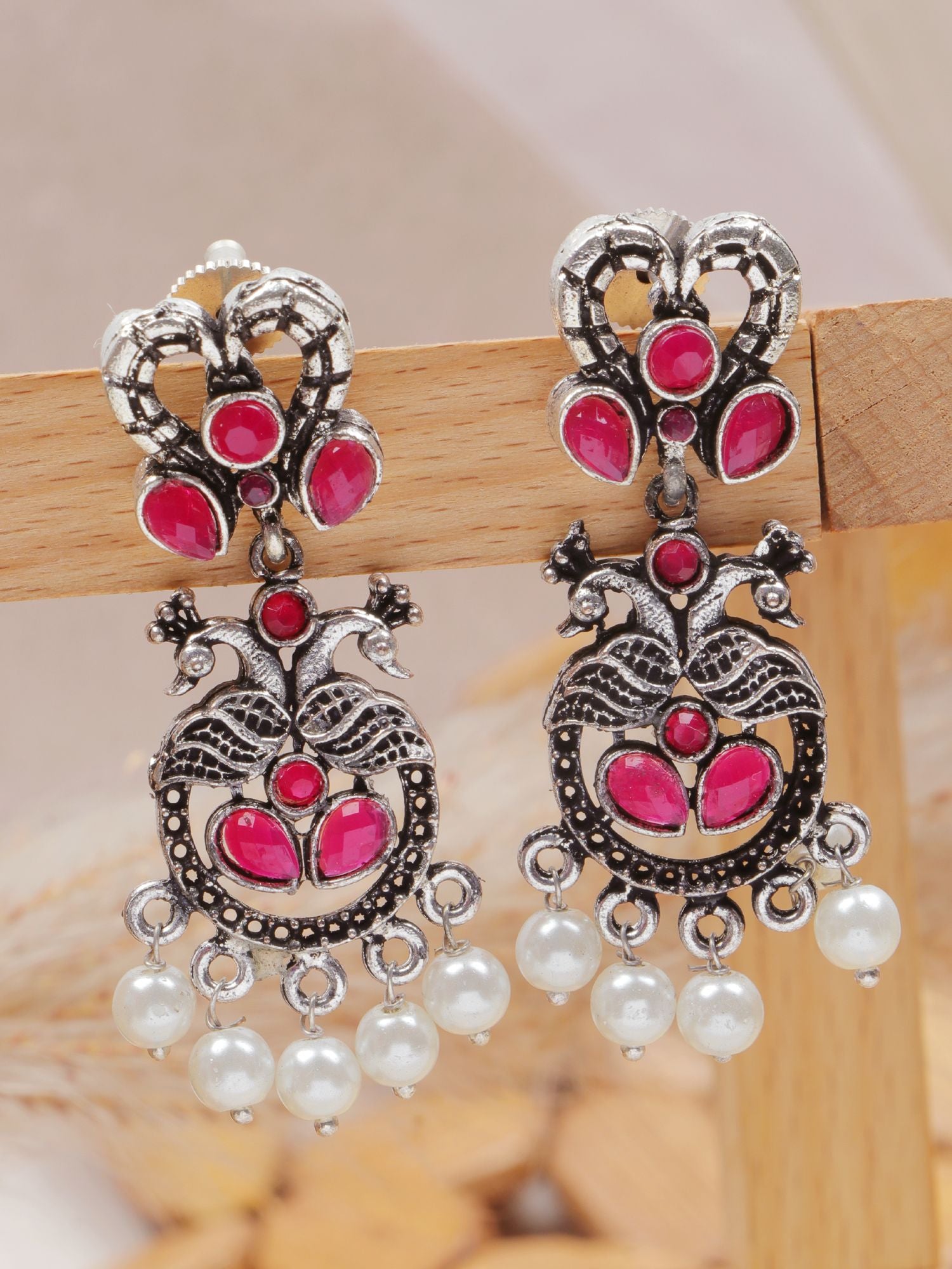 Antique pink stone asymmetric earrings with oxidized silver peacock design, perfect for festive, wedding wear for women&girls
